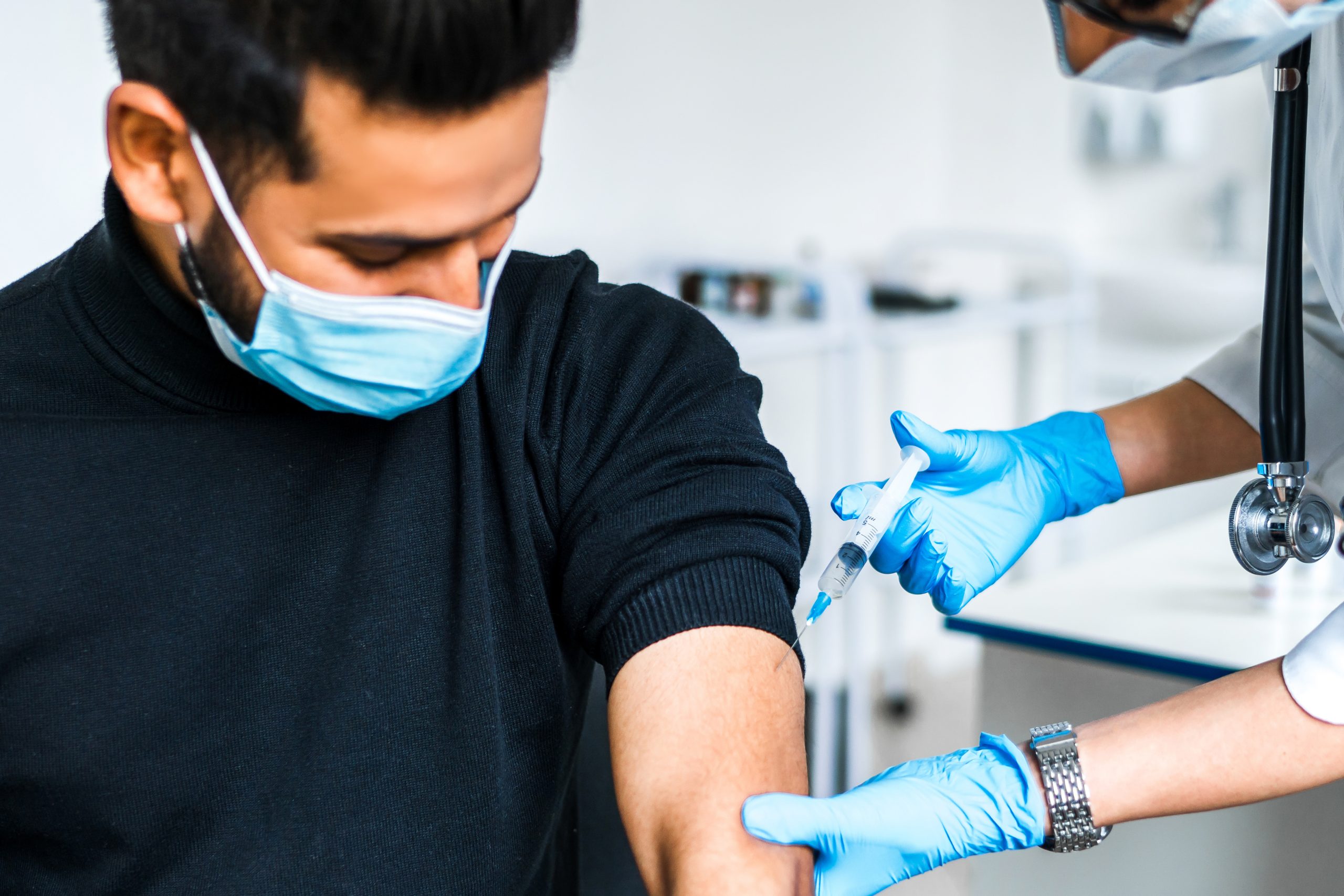close up of a vaccination patient, the doctor injects a coronavi
